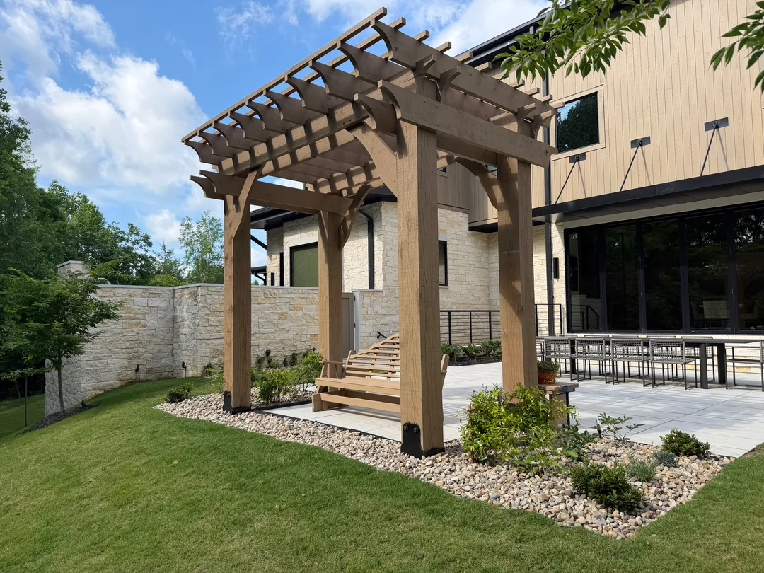 Cedar pergola and stone hardscape at a completed landscape project